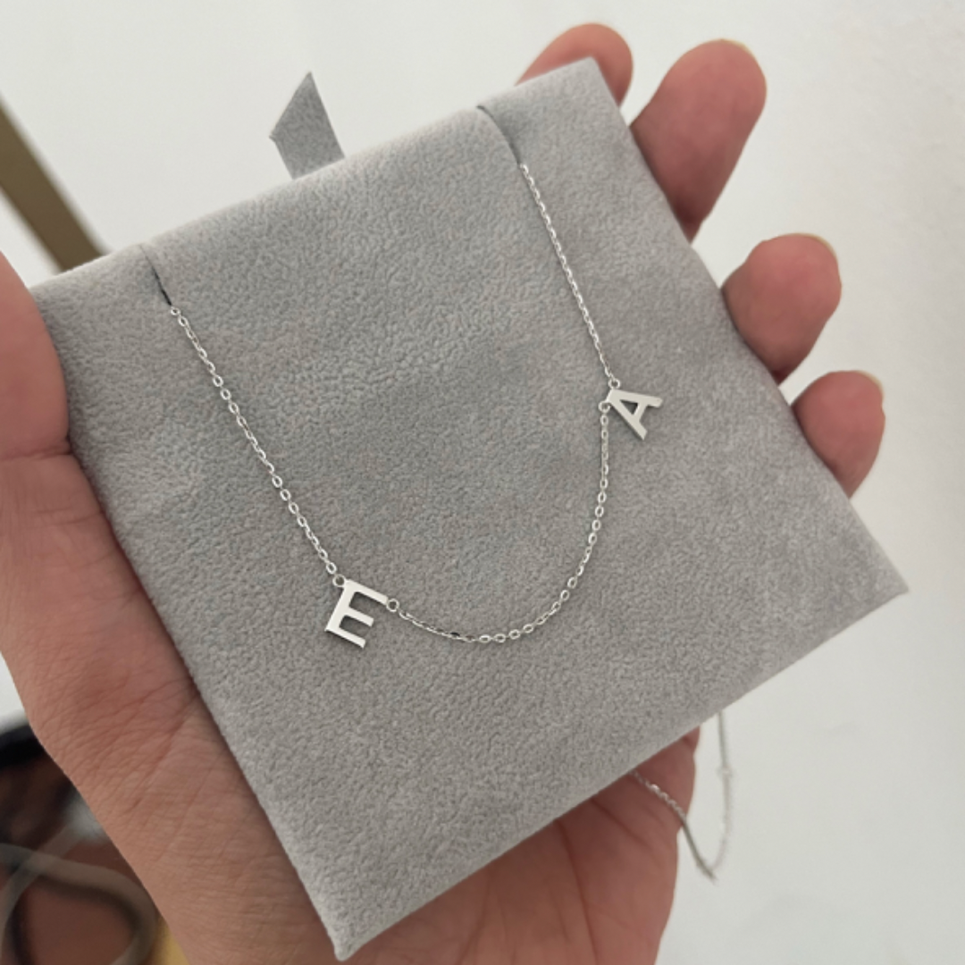 18K white gold two-initial necklace with A and E letters on a grey display card