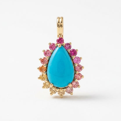 A gold teardrop pendant featuring a large turquoise-blue center stone surrounded by a halo of small pink, orange, and clear accent stones on a white background.