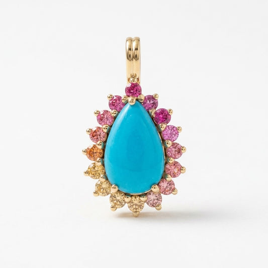 A gold teardrop pendant featuring a large turquoise-blue center stone surrounded by a halo of small pink, orange, and clear accent stones on a white background.