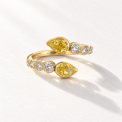 Afterglow 18K gold open ring with two bezel-set yellow pear diamonds and graduating white diamonds, front view