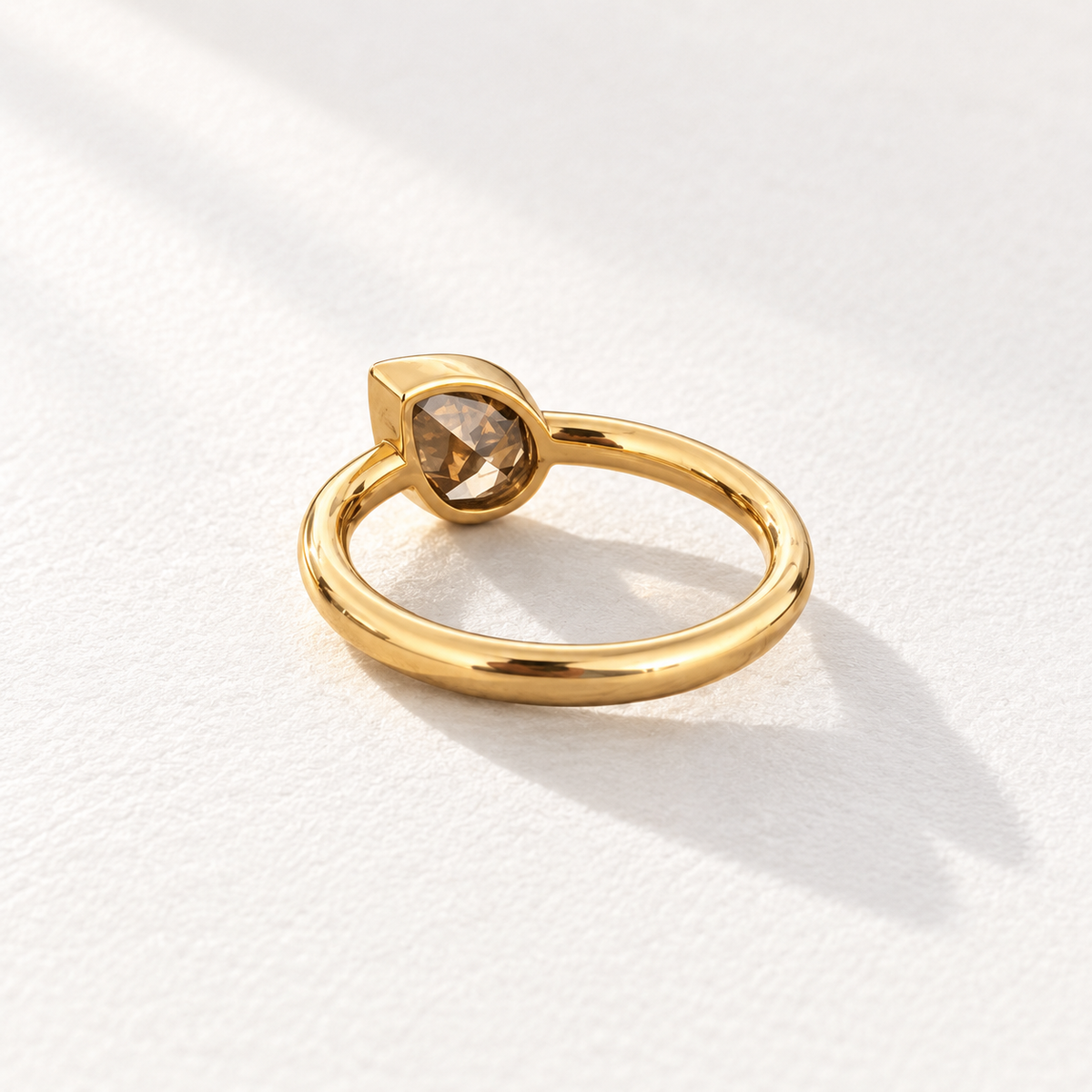 Ember 18K gold brown pear diamond ring showing the open-backed setting