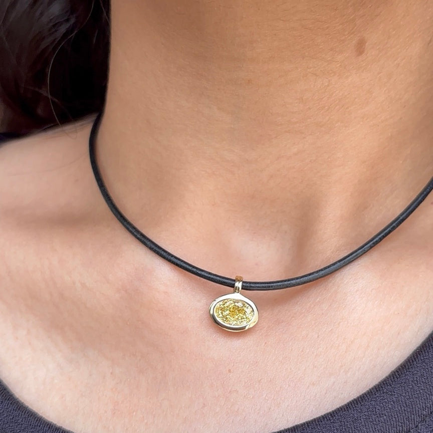 Solstice 2 carat IGI-certified yellow oval diamond charm worn on a black cord