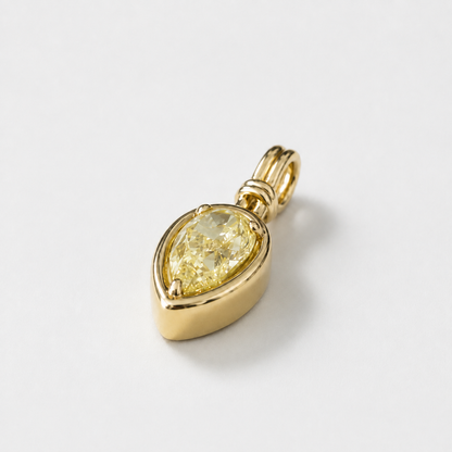 Angled view of Sundrop yellow pear diamond charm in polished yellow gold.