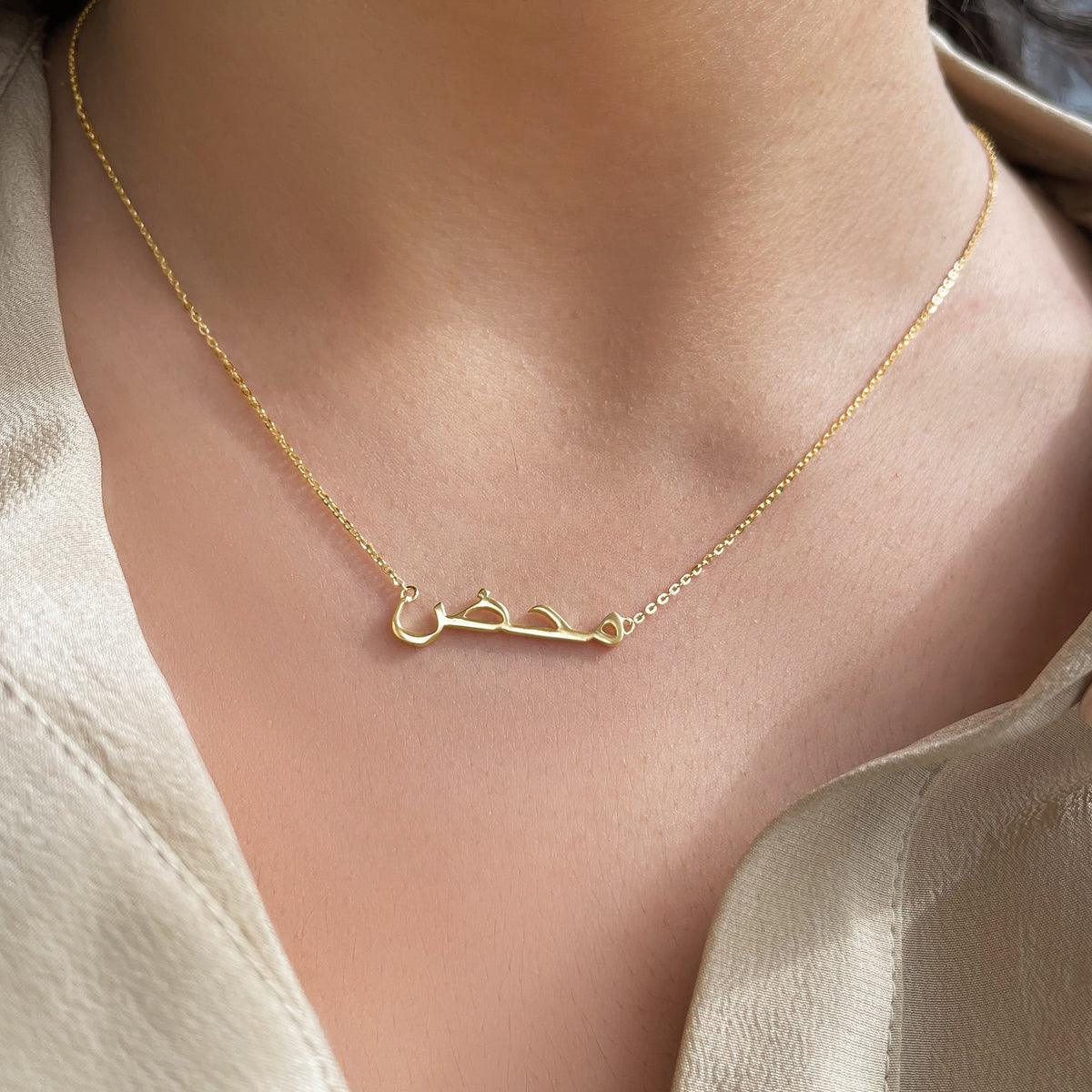 Personalised 18K gold Arabic name necklace on a fine chain.